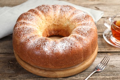 Freshly baked sponge cake and tea on wooden table, closeup