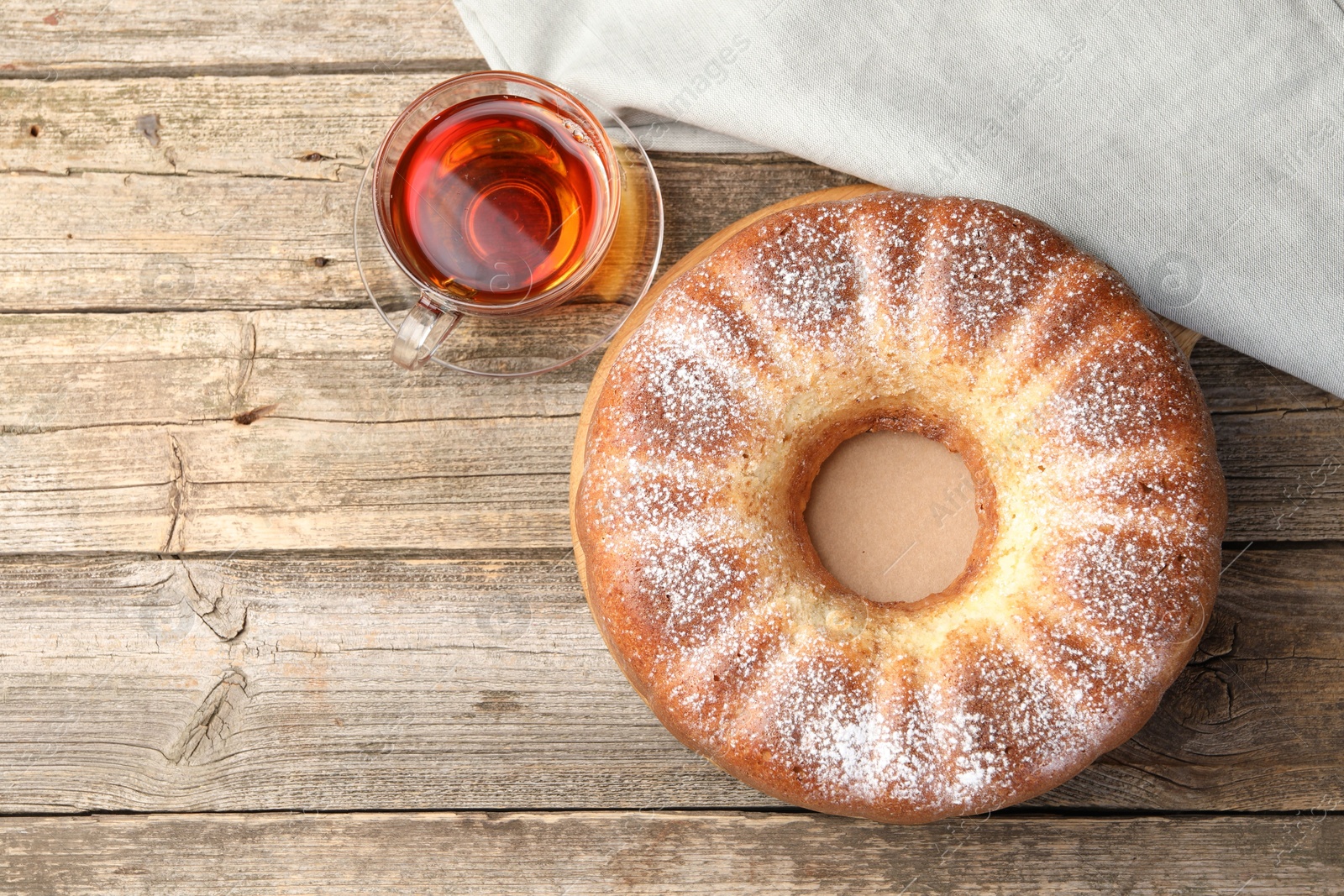 Photo of Freshly baked sponge cake and tea on wooden table, top view. Space for text