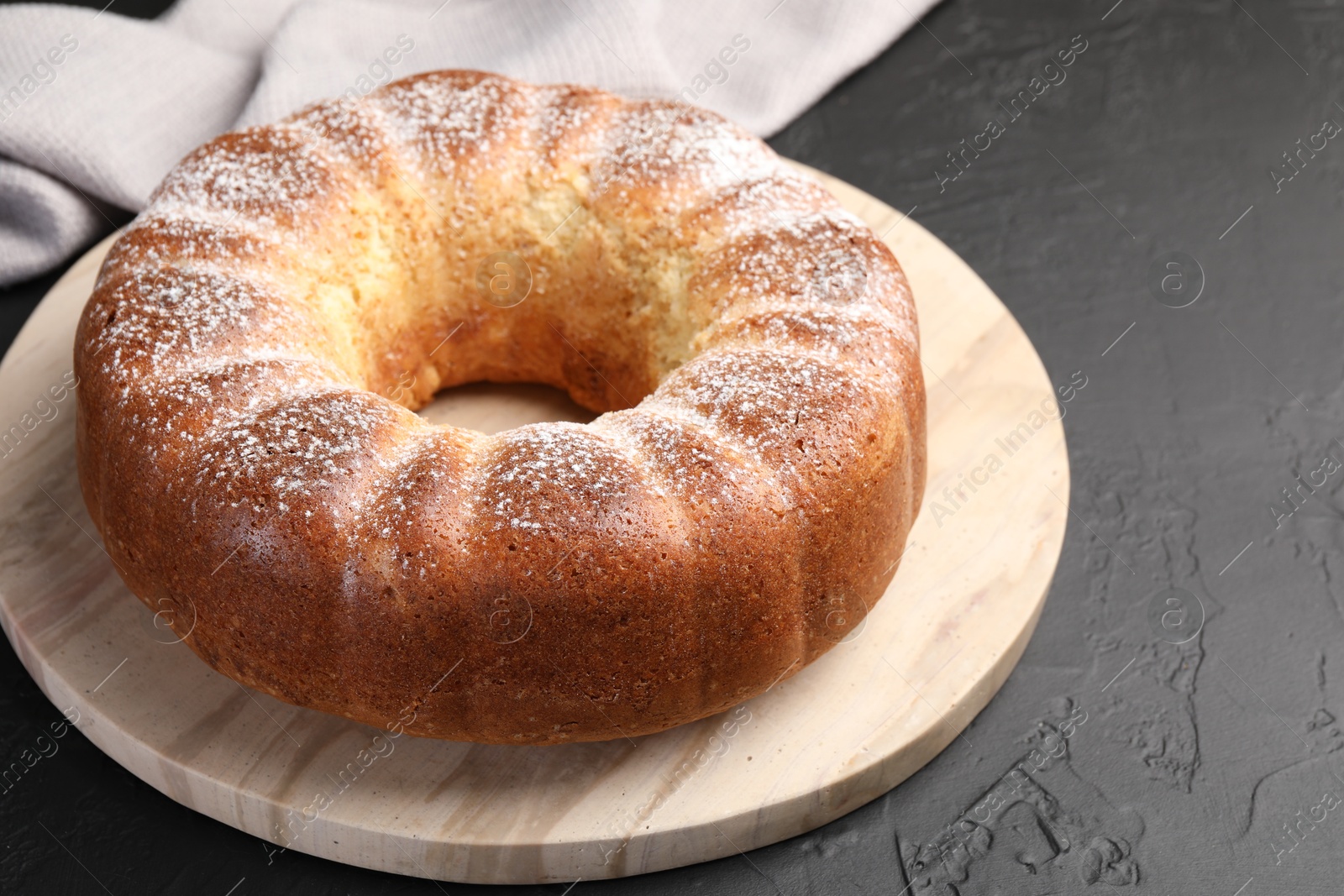 Photo of Freshly baked sponge cake on black table, closeup