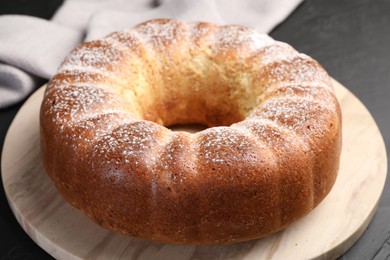 Photo of Freshly baked sponge cake on black table, closeup