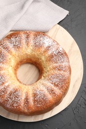 Freshly baked sponge cake on black table, top view