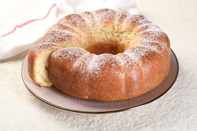 Photo of Freshly baked sponge cake on white textured table, closeup