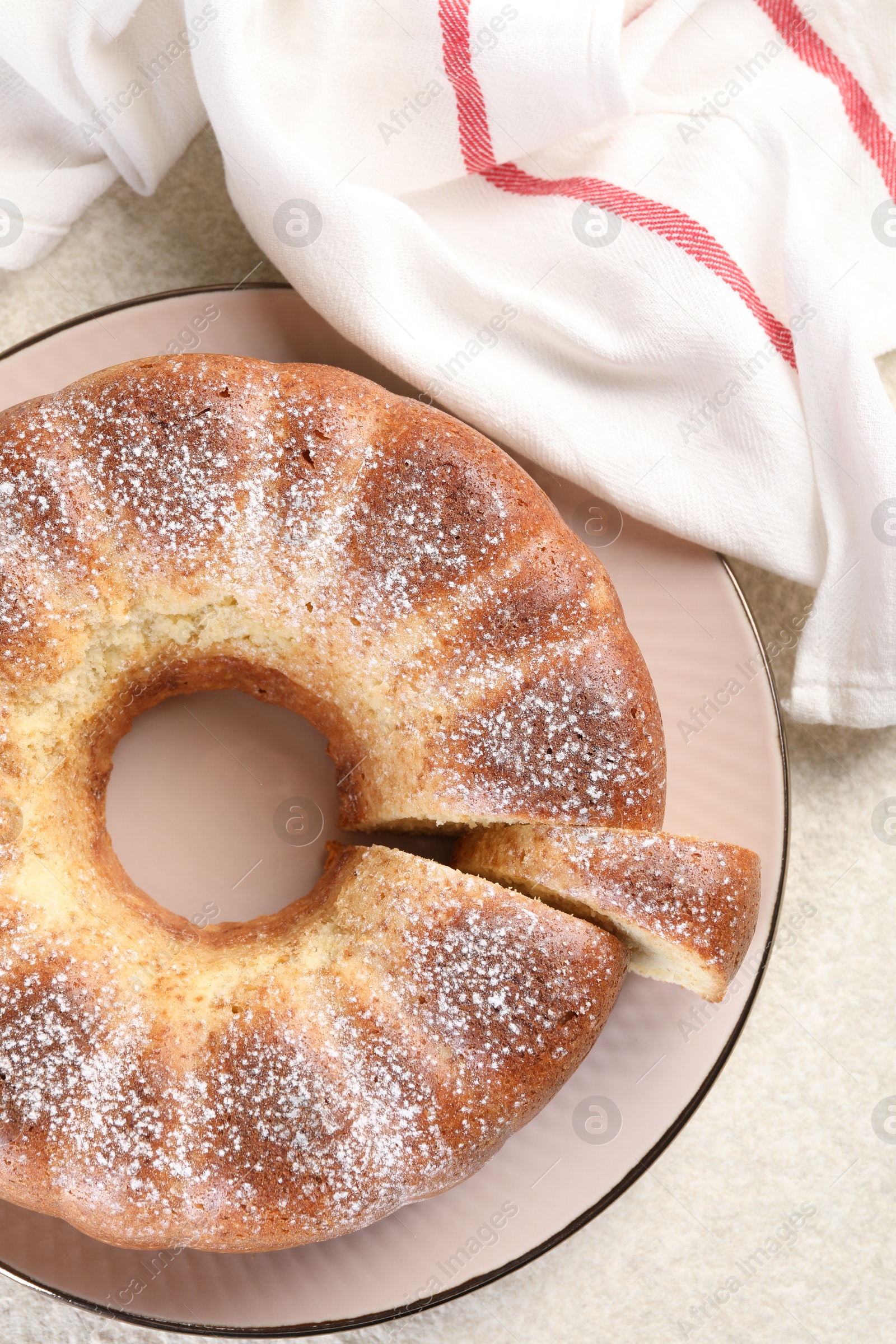 Photo of Freshly baked sponge cake on white textured table, top view