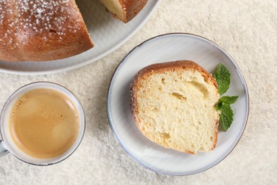 Piece of freshly baked sponge cake, mint and coffee on white textured table, top view