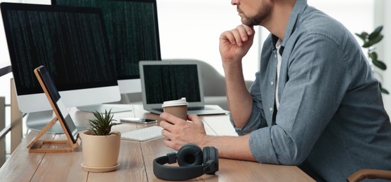 Programmer with coffee working at desk in office, closeup. Banner design