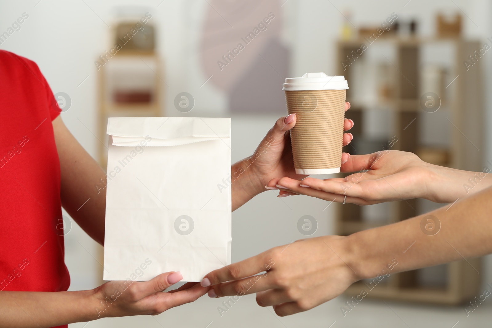 Photo of Fast-food worker giving customer's order indoors, closeup