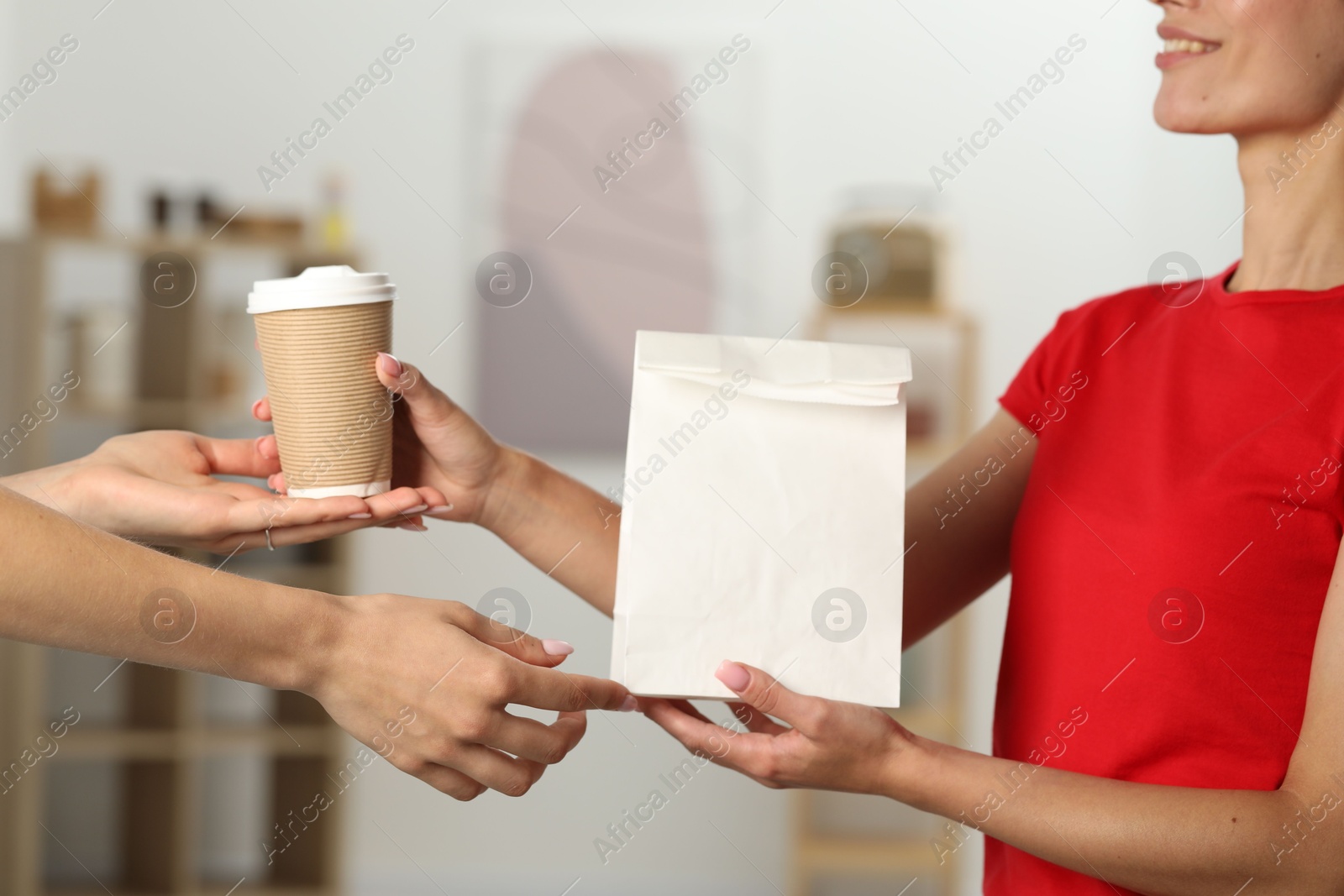 Photo of Fast-food worker giving customer's order indoors, closeup