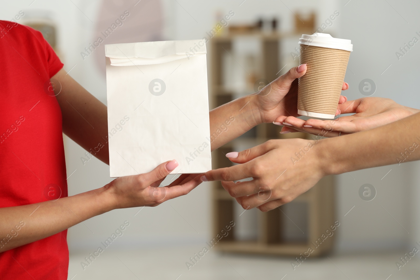 Photo of Fast-food worker giving customer's order indoors, closeup