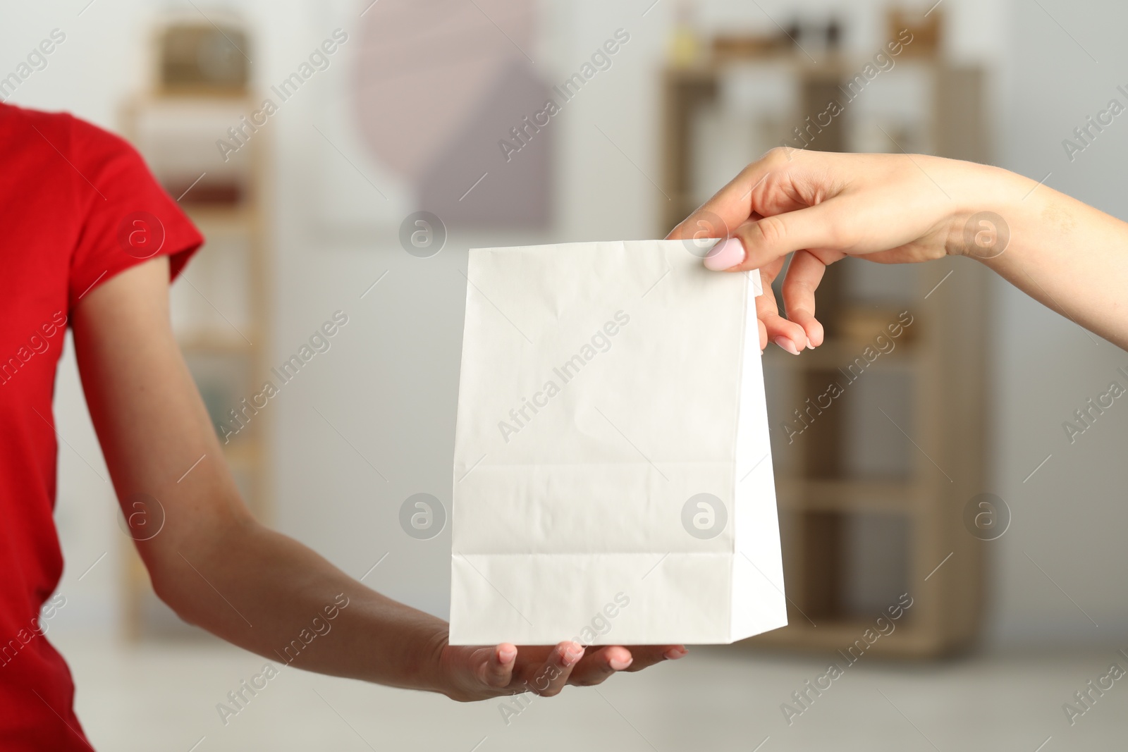 Photo of Fast-food worker giving customer's order indoors, closeup