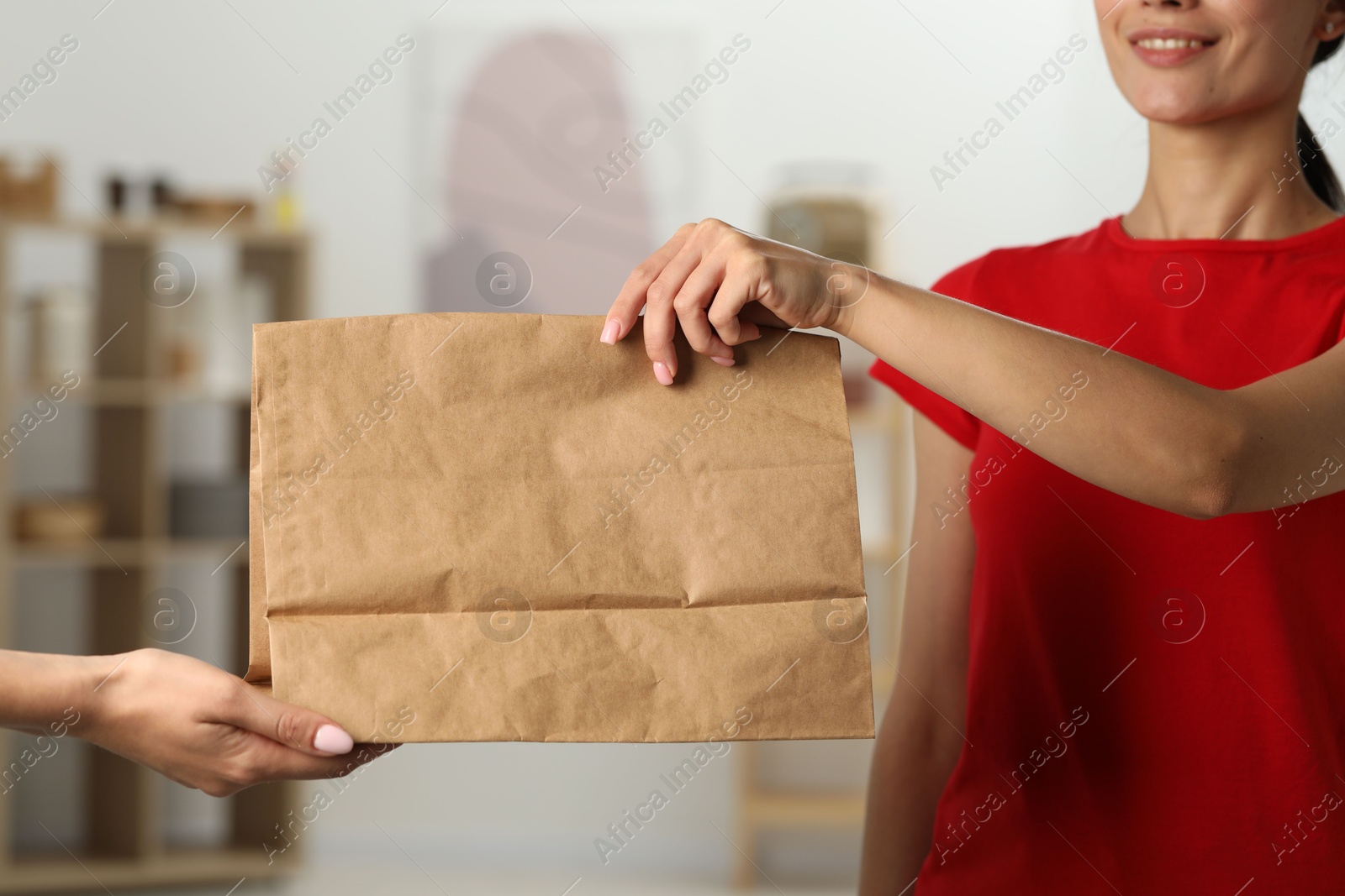 Photo of Fast-food worker giving customer's order indoors, closeup