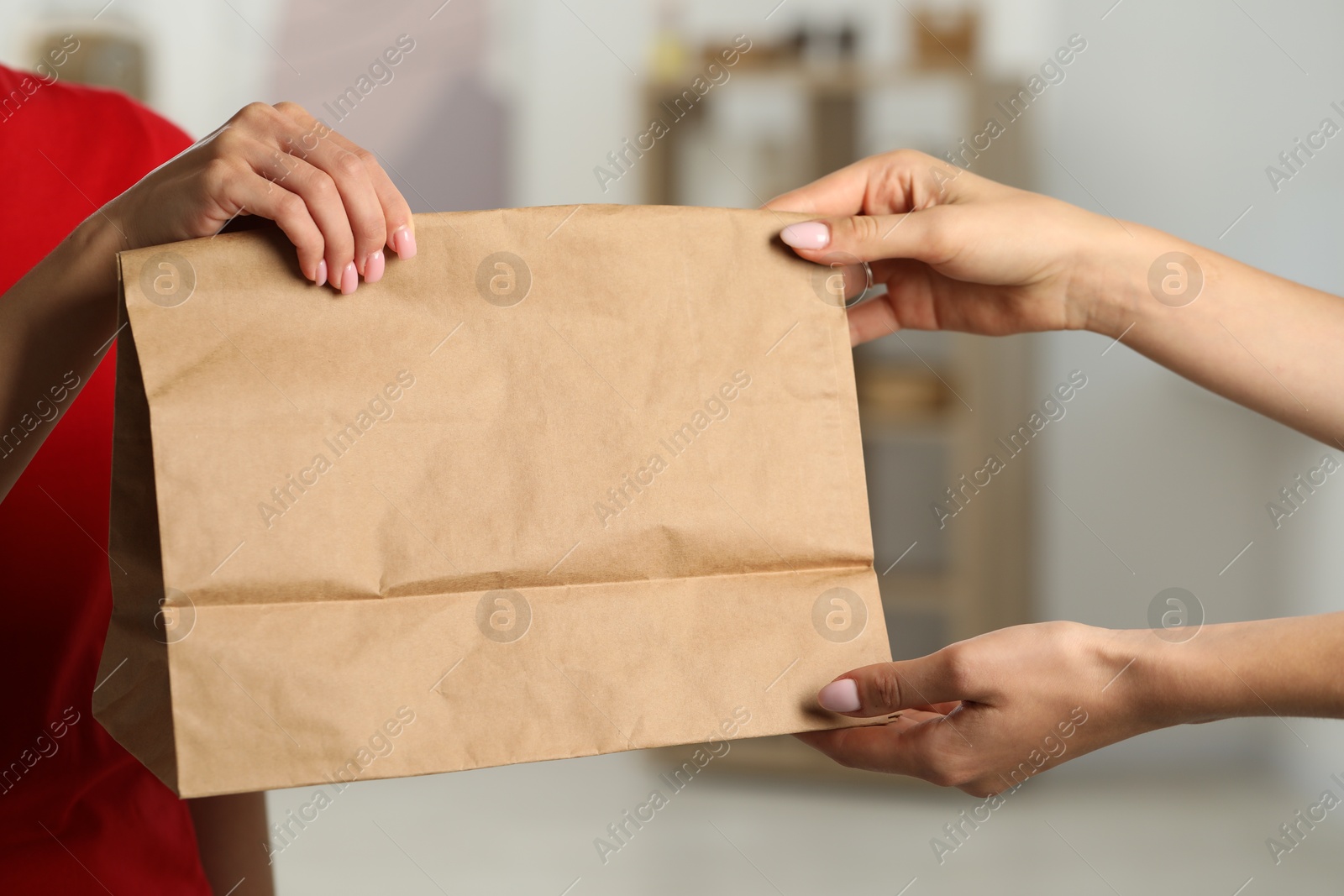 Photo of Fast-food worker giving customer's order indoors, closeup