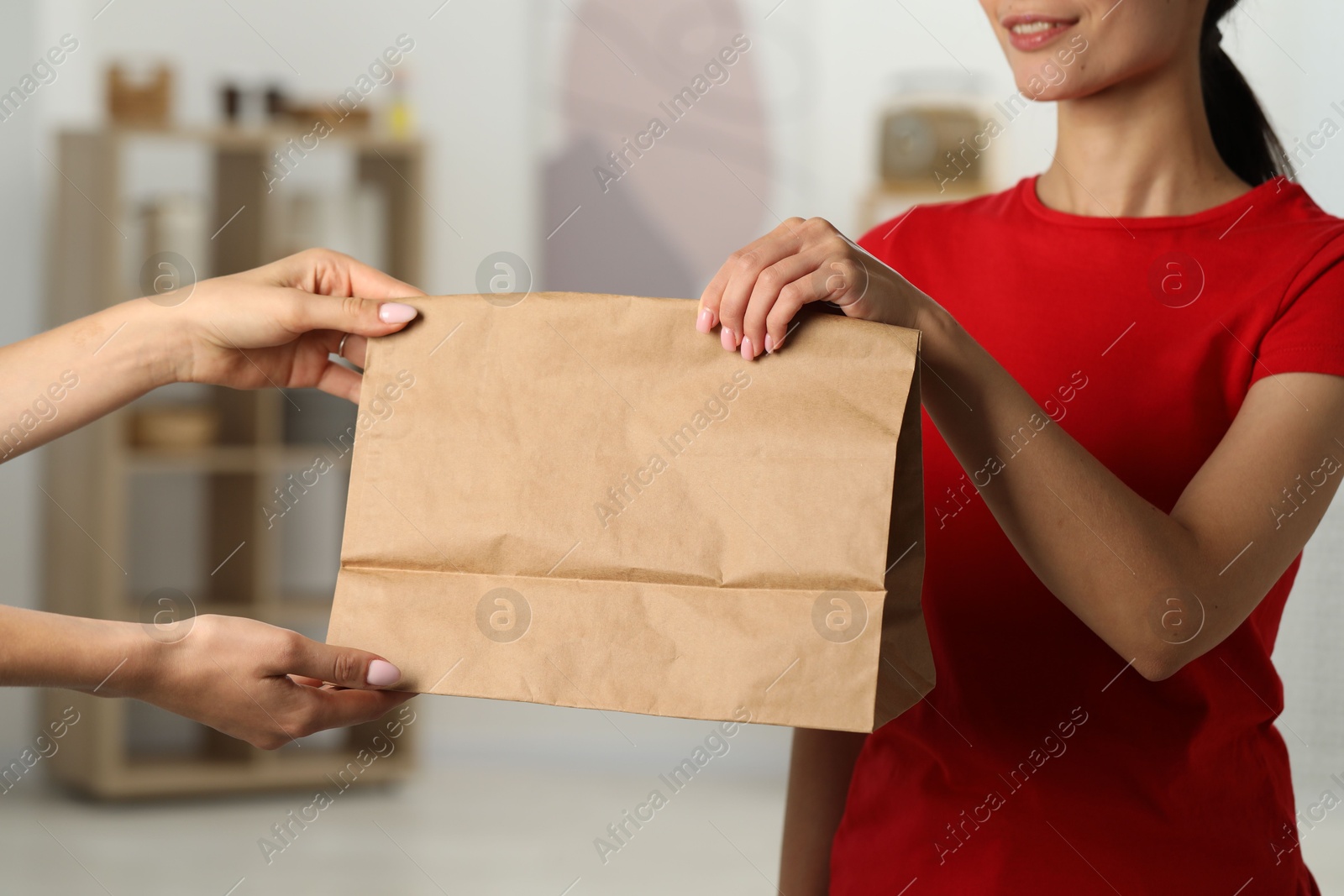 Photo of Fast-food worker giving customer's order indoors, closeup