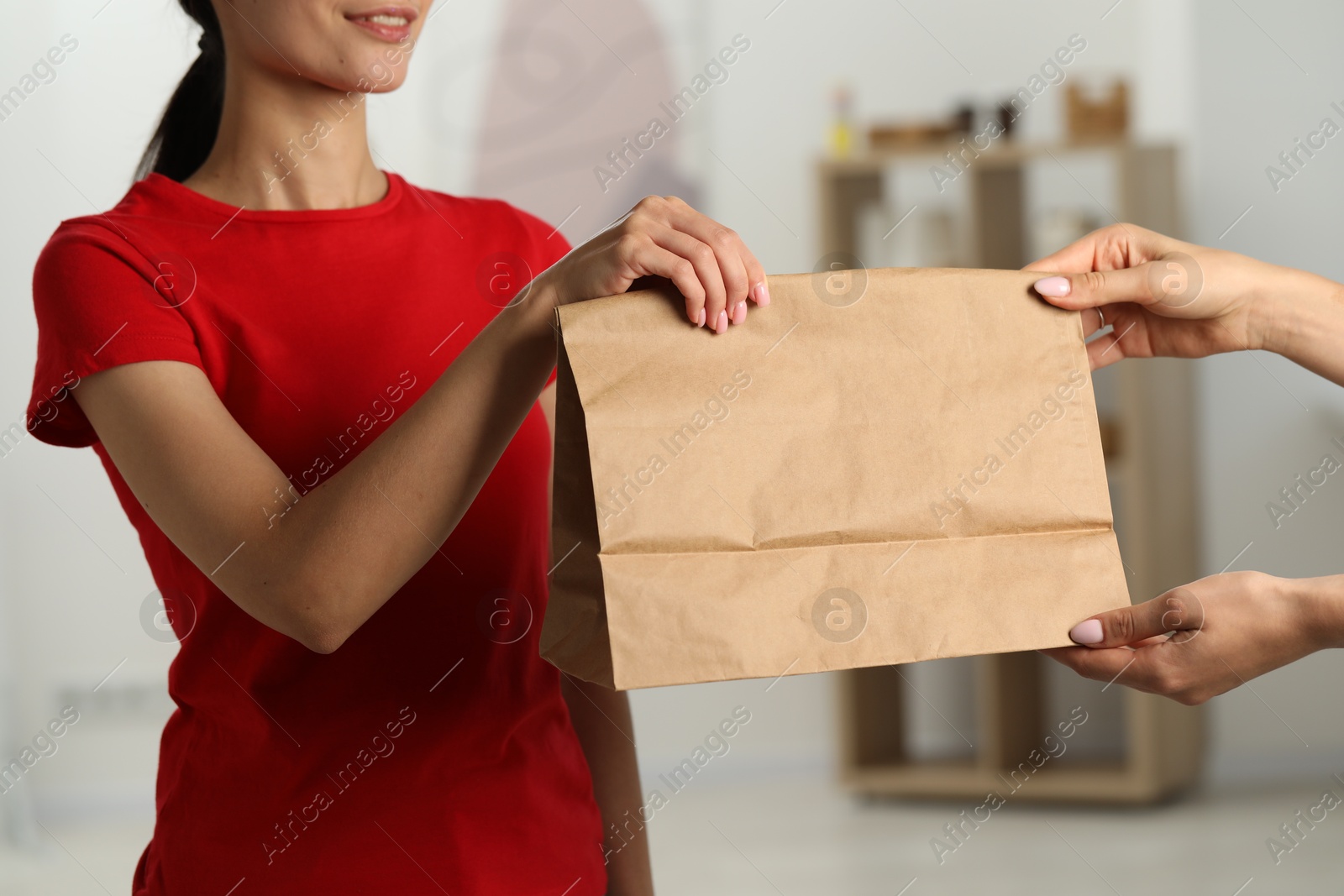 Photo of Fast-food worker giving customer's order indoors, closeup