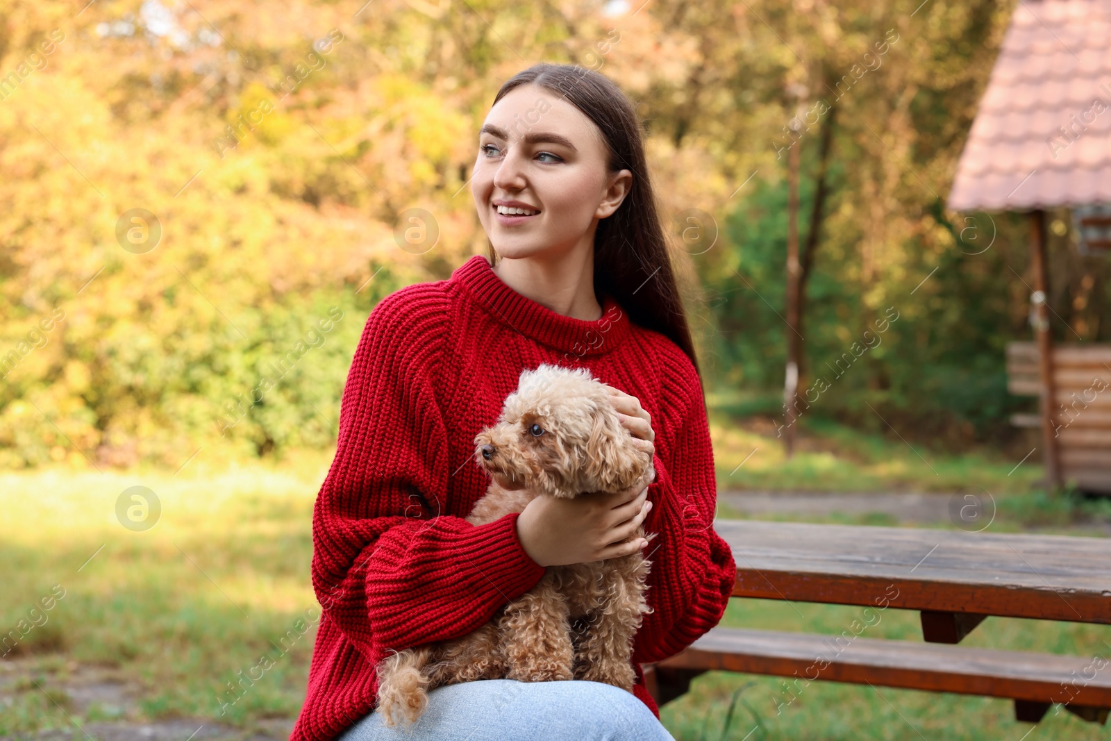 Photo of Smiling woman with cute dog in autumn park