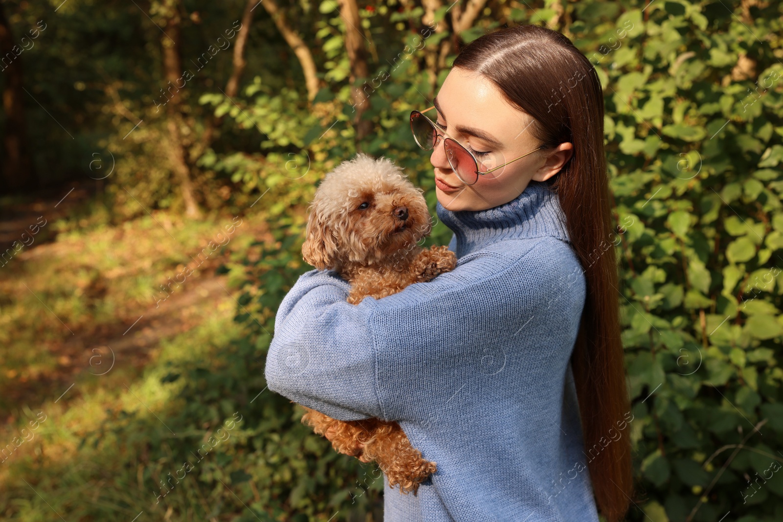 Photo of Woman with cute dog in autumn park