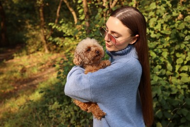 Photo of Woman with cute dog in autumn park