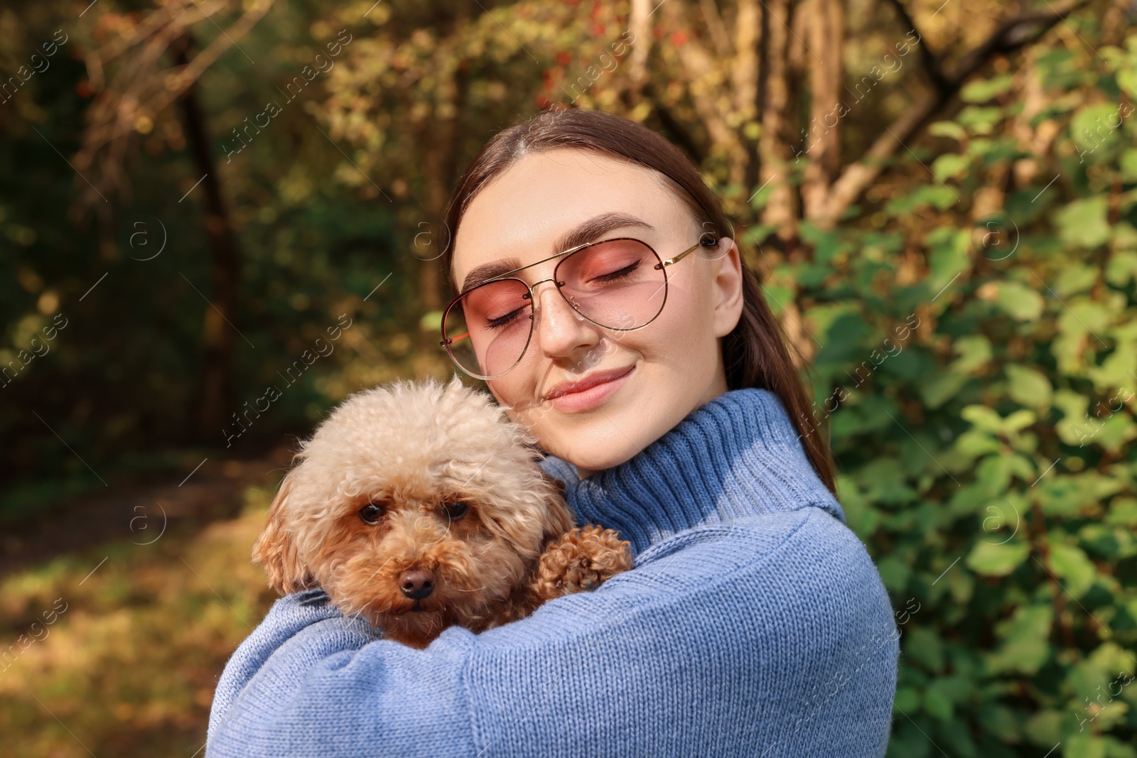 Photo of Woman with cute dog in autumn park