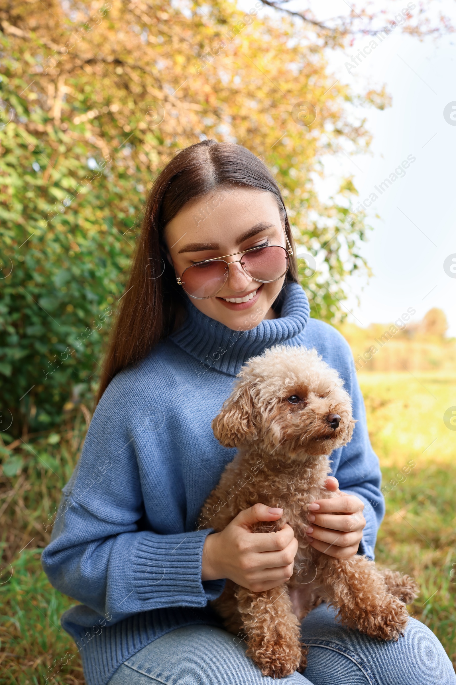 Photo of Smiling woman with her cute dog outdoors