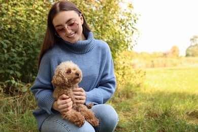 Photo of Smiling woman with cute dog outdoors. Space for text