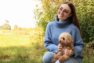 Photo of Smiling woman with cute dog outdoors. Space for text