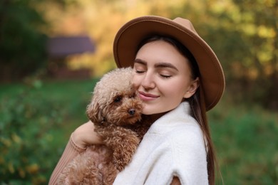 Portrait of woman with cute dog outdoors