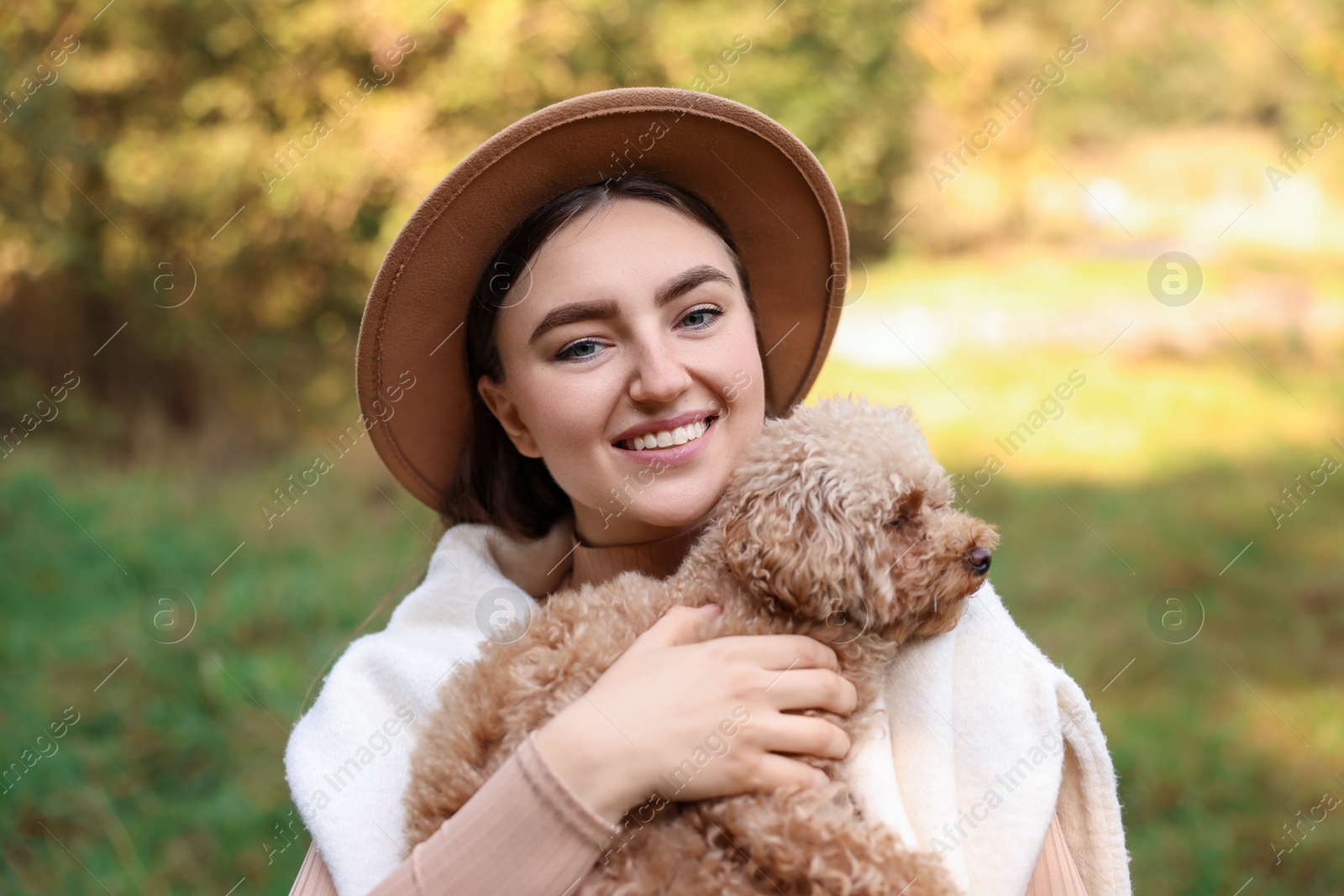 Photo of Portrait of smiling woman with cute dog outdoors