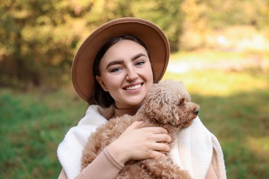 Portrait of smiling woman with cute dog outdoors