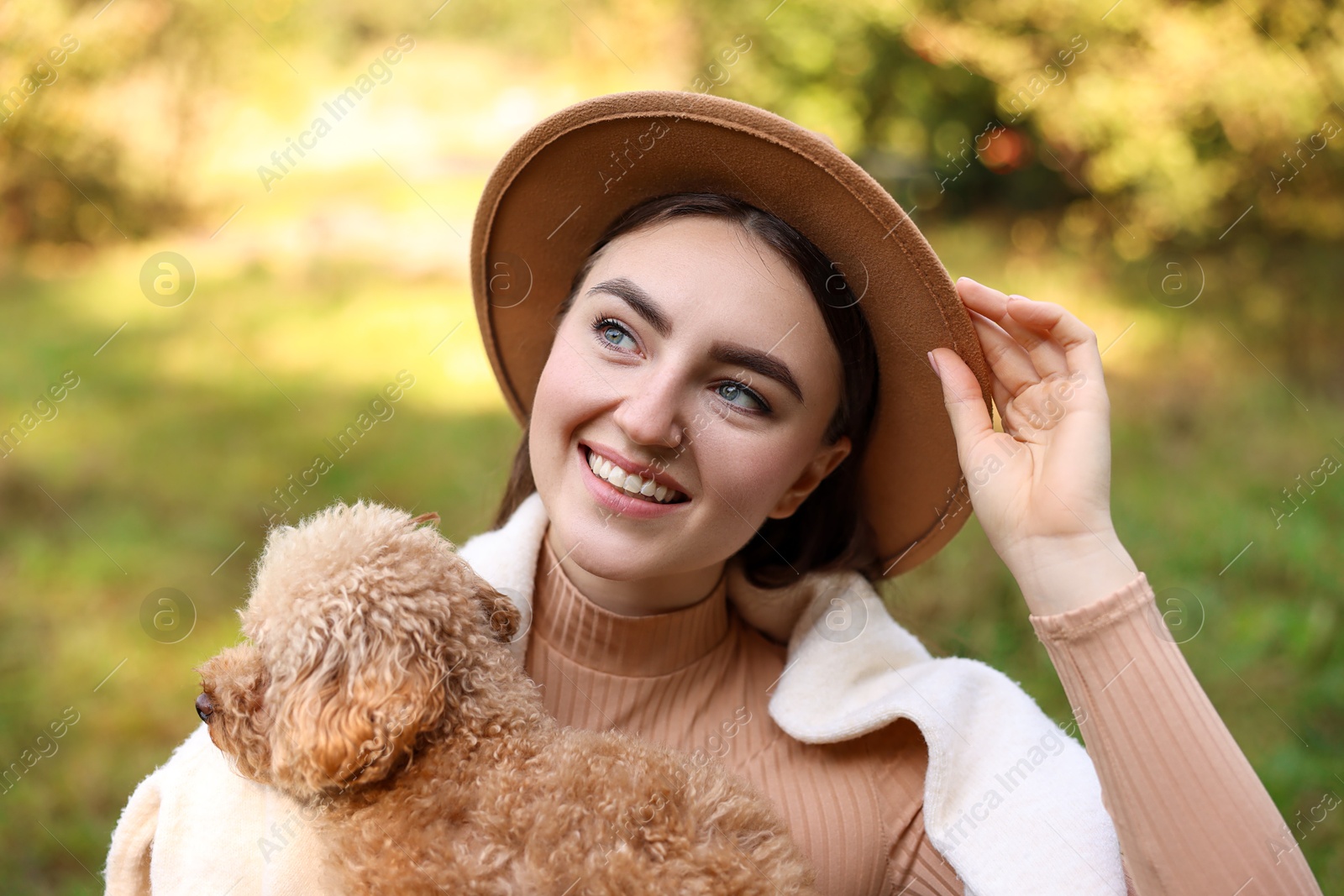 Photo of Portrait of smiling woman with cute dog outdoors