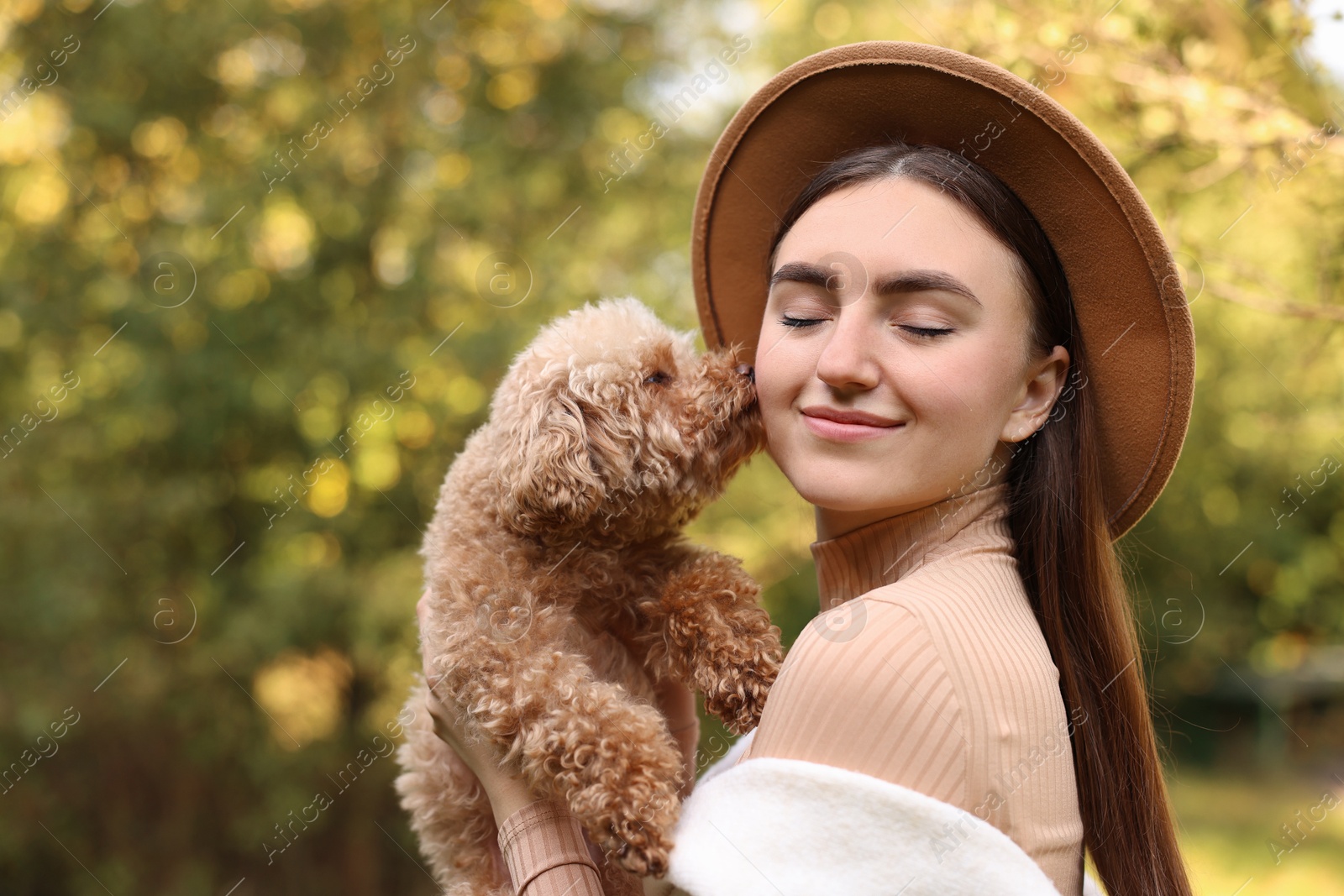 Photo of Woman with cute dog in autumn park. Space for text