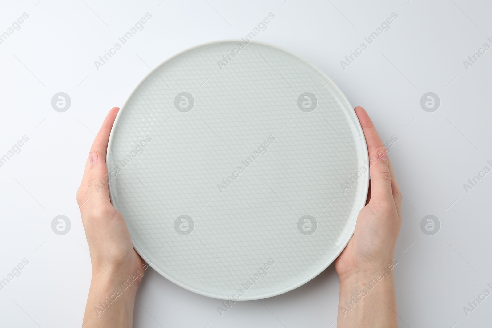 Photo of Woman with empty ceramic plate on white background, top view