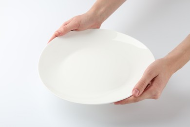 Photo of Woman with empty ceramic plate on white background, closeup