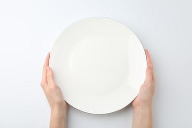 Photo of Woman with empty ceramic plate on white background, top view