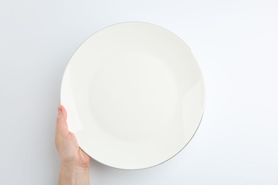 Photo of Woman with empty ceramic plate on white background, top view