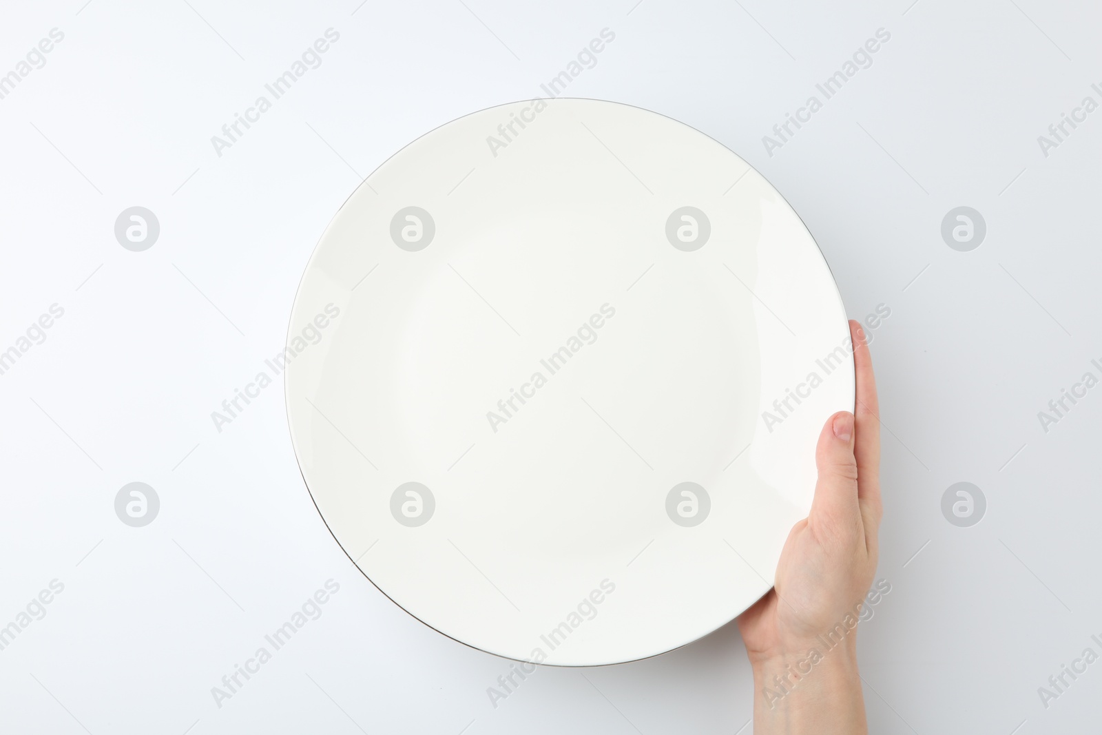 Photo of Woman with empty ceramic plate on white background, top view