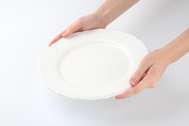 Woman with empty ceramic plate on white background, closeup