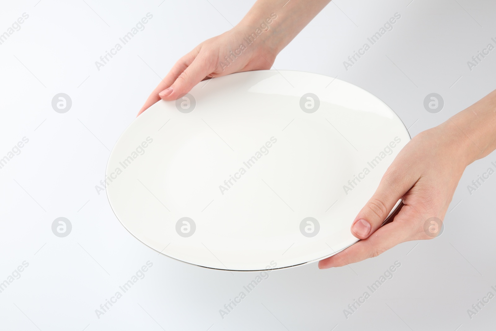 Photo of Woman with empty ceramic plate on white background, closeup