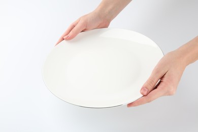 Photo of Woman with empty ceramic plate on white background, closeup