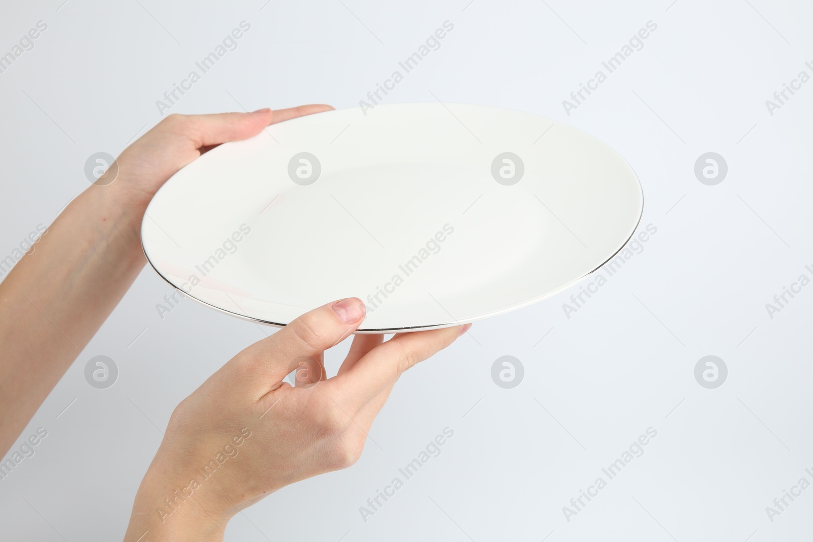 Photo of Woman with empty ceramic plate on white background, closeup