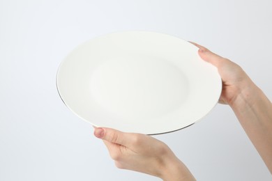 Photo of Woman with empty ceramic plate on white background, closeup