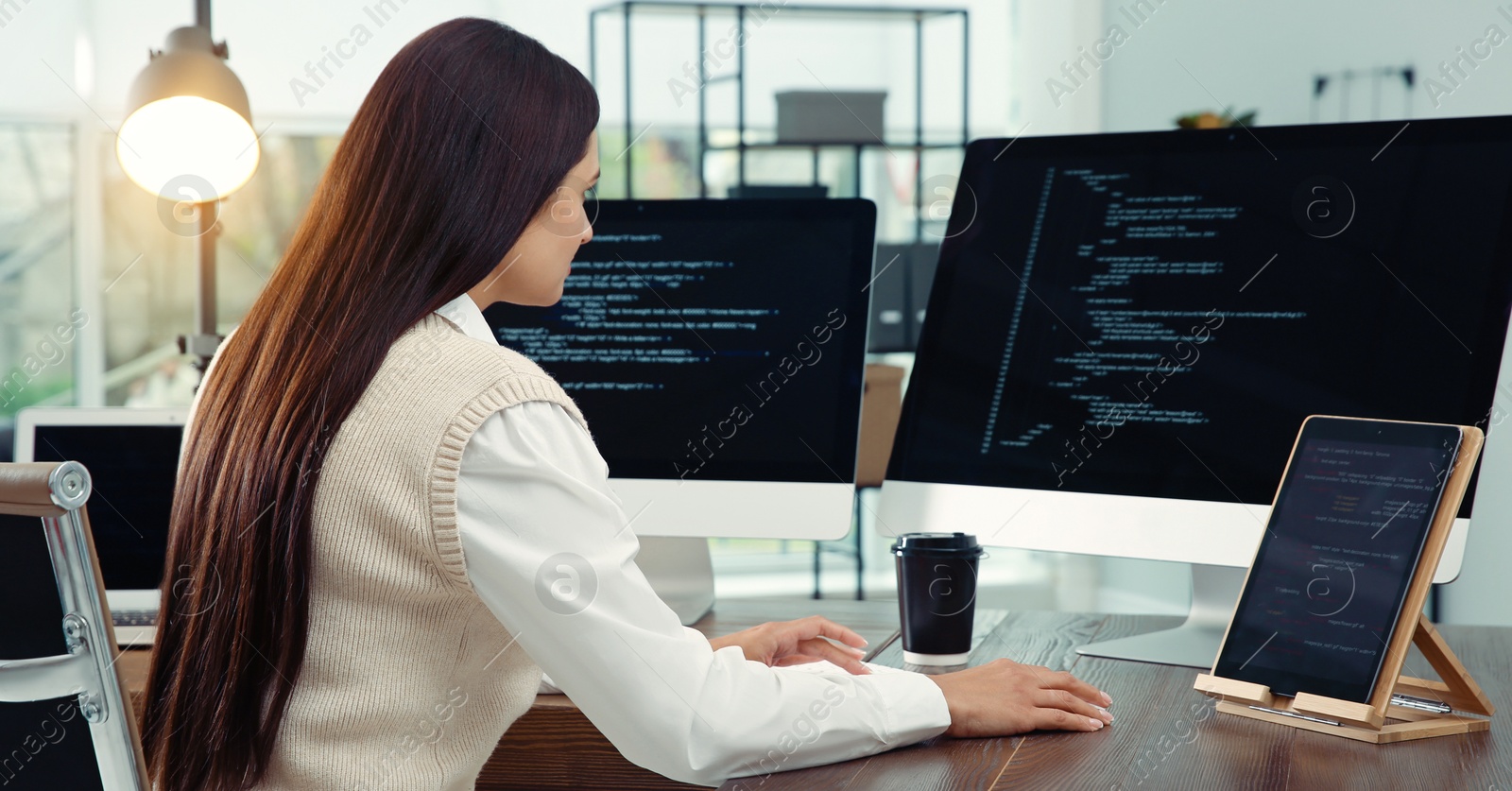 Image of Programmer working at desk in modern office. Banner design