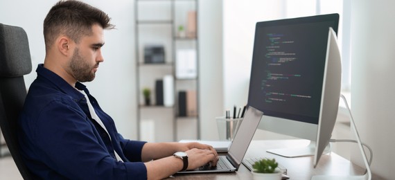 Programmer working at desk in office. Banner design