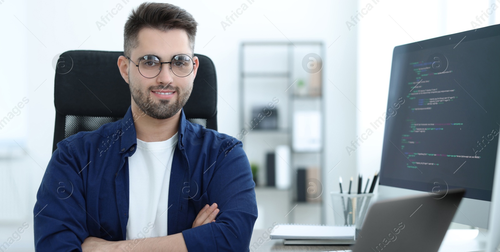 Image of Young programmer working in office. Banner design