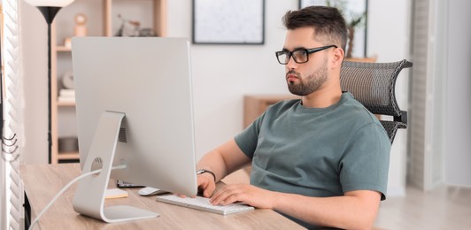 Image of Programmer working with computer at desk in office. Banner design