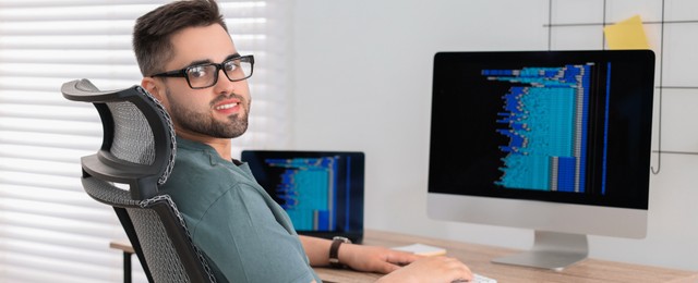 Programmer working at desk in office. Banner design