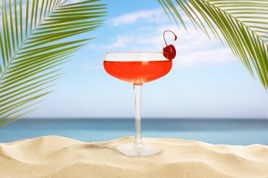 Image of Summer beach with delicious cocktail, palm leaves and golden sand