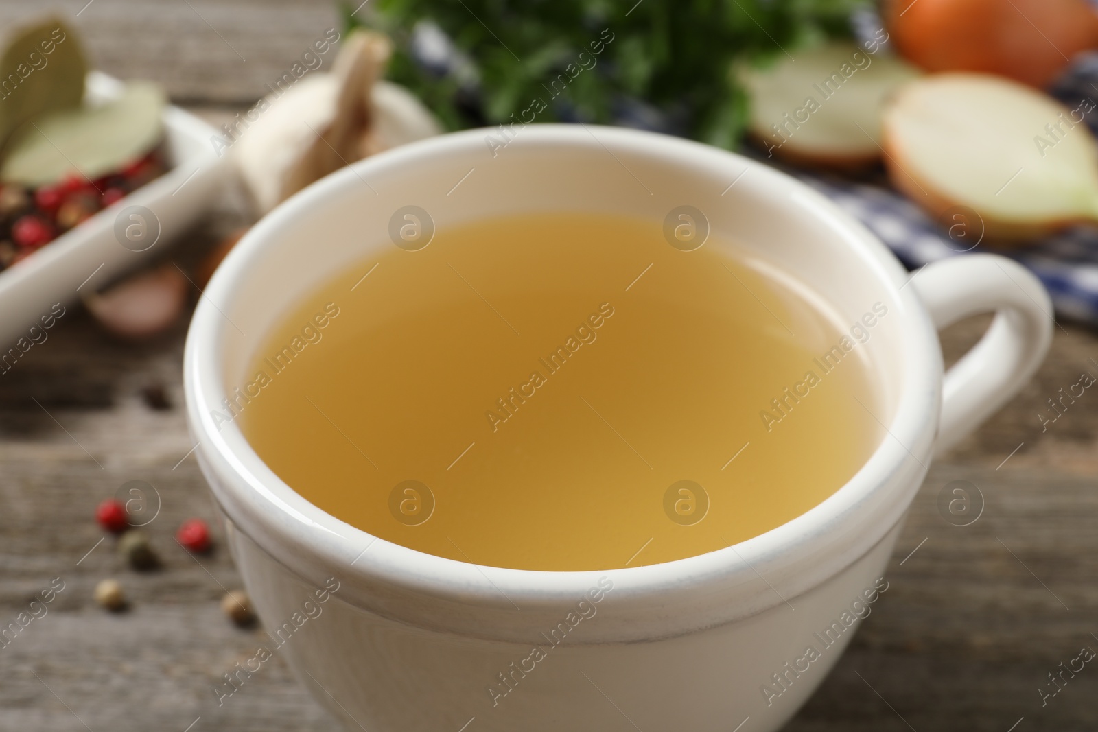 Photo of Hot delicious bouillon in cup on table, closeup