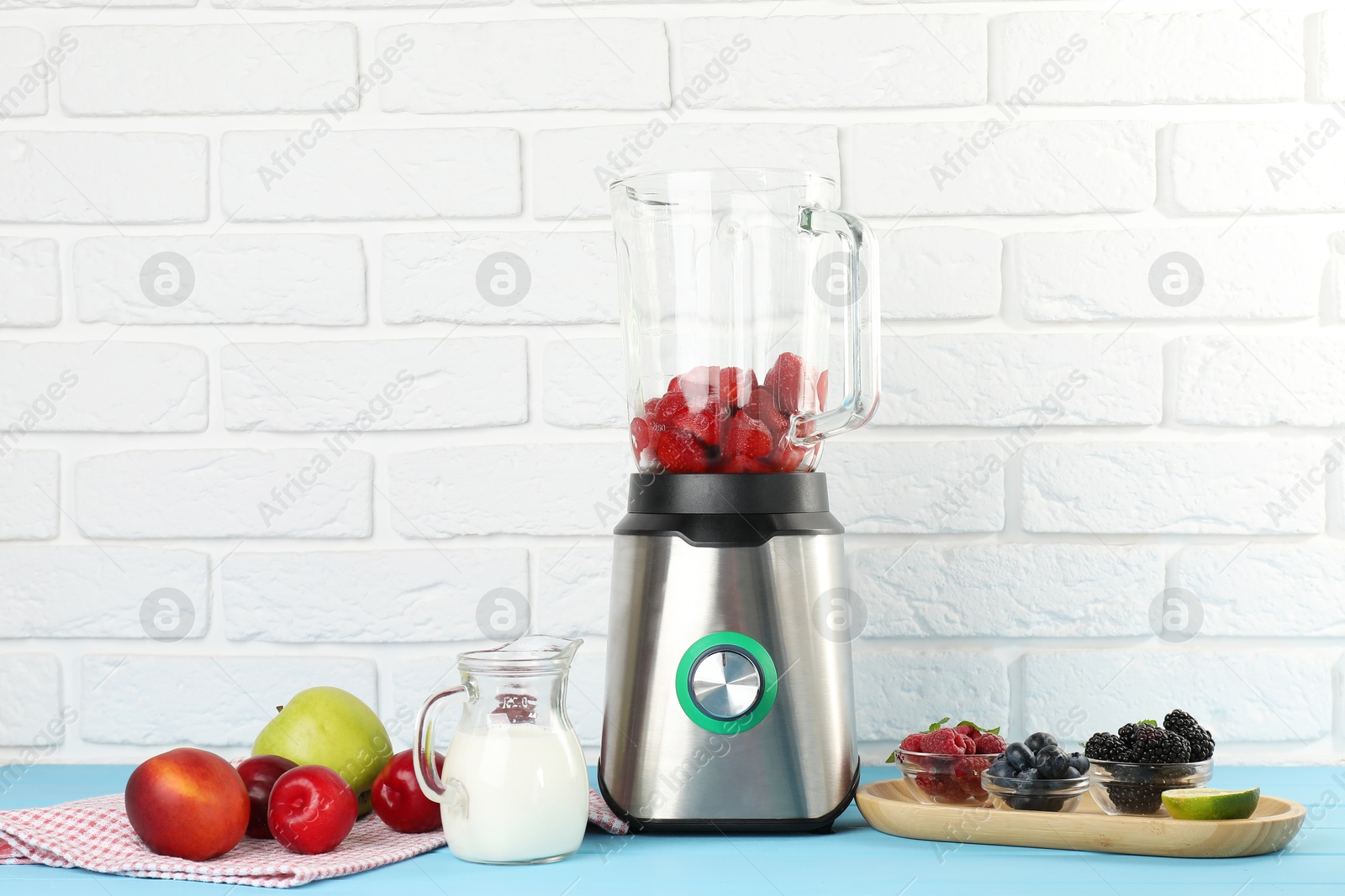 Photo of Blender and fresh ingredients on light blue wooden table