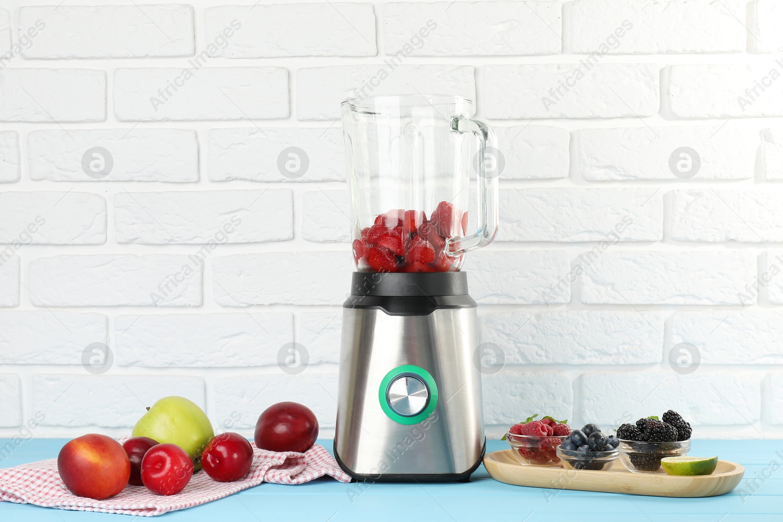 Photo of Blender and fresh ingredients on light blue wooden table