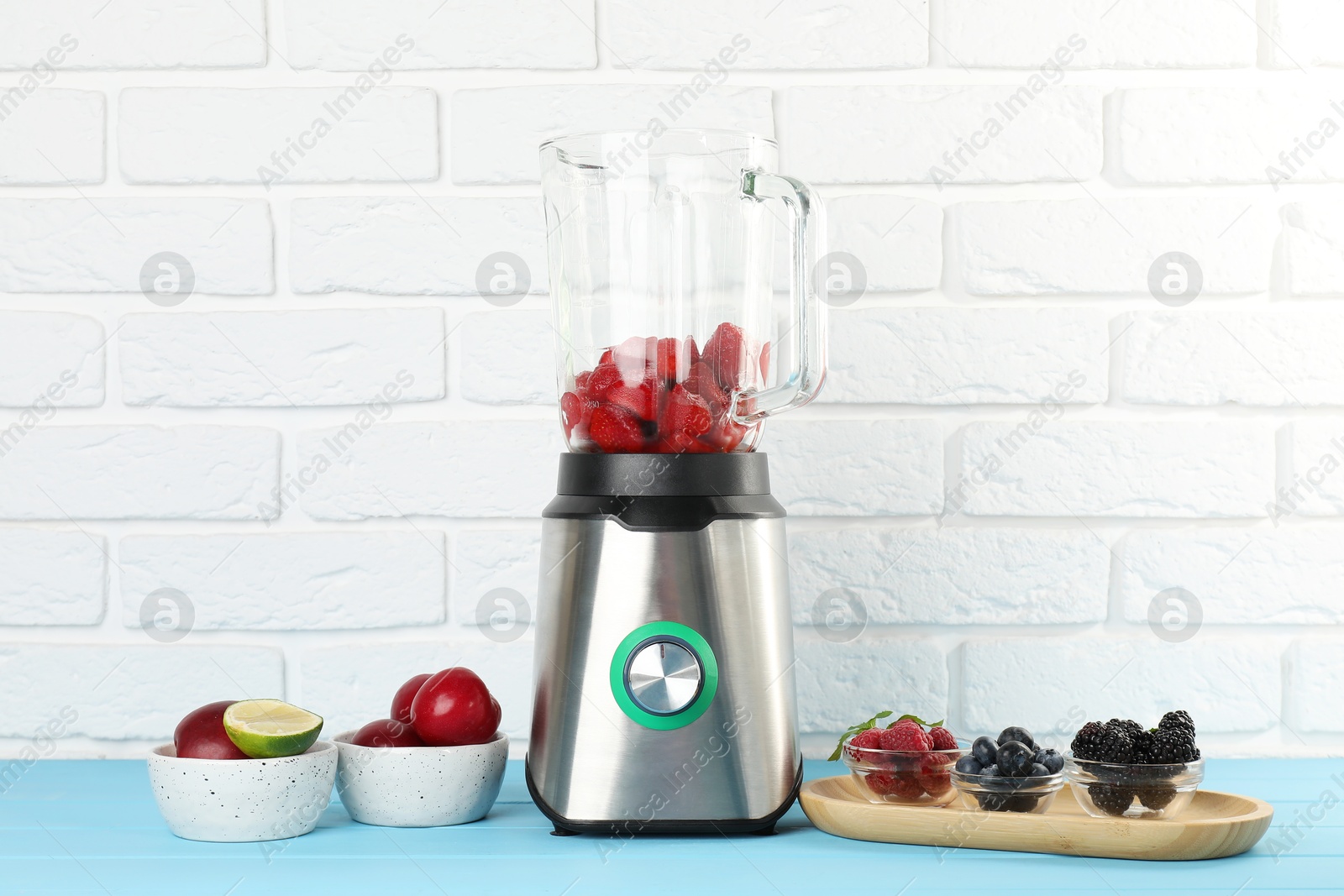 Photo of Blender and fresh ingredients on light blue wooden table