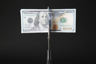 Photo of Budgeting. Cutting dollar banknotes with scissors on black background, closeup